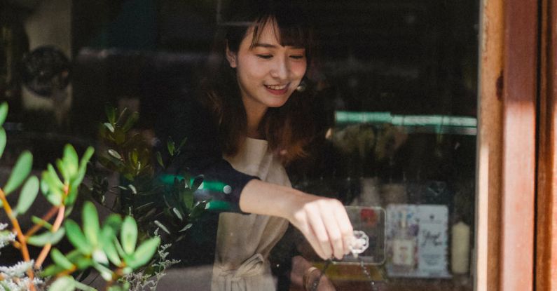 Close Sale - Ethnic woman in casual clothes hanging up sign on door after end of workday