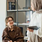 Business Continuity - Two women in hijab talking in an office