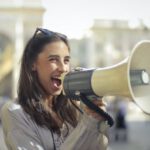 Marketing Message - Cheerful young woman screaming into megaphone