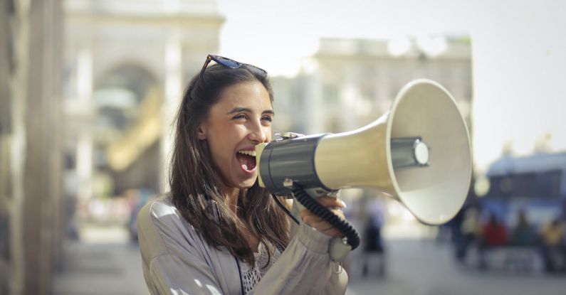 Marketing Message - Cheerful young woman screaming into megaphone