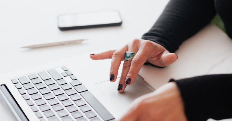 Serial Entrepreneur - Crop female using touchpad on laptop in office