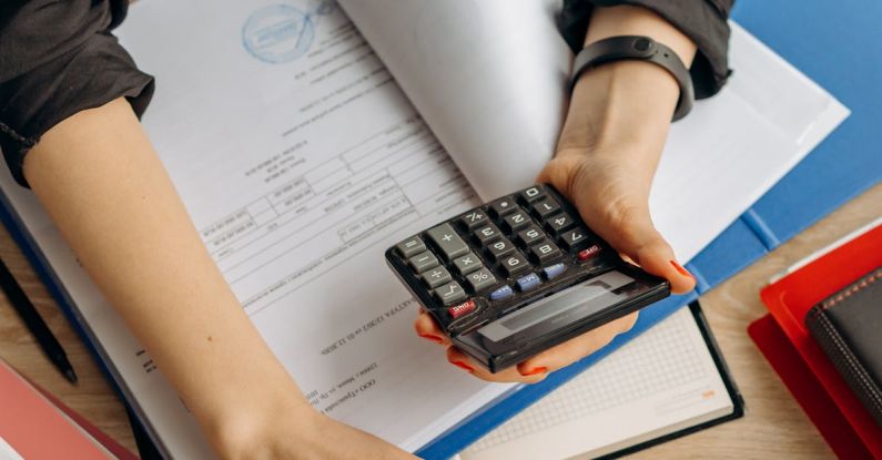 Liability Insurance - Person Holding Black Calculator While Using Laptop