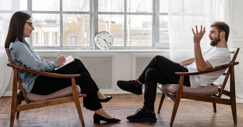 Psychology - Person in Black Pants and Black Shoes Sitting on Brown Wooden Chair